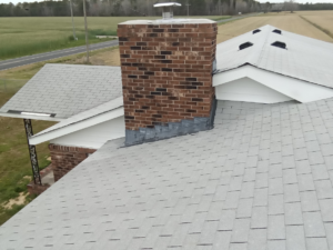 A grey shingle roof before a metal roof is installed on it.