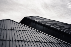 A large black and grey metal roof against an open sky