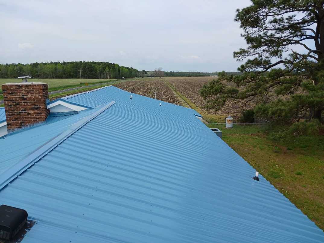 A light blue metal roof installed on a residential property by Gator Metal Roofing