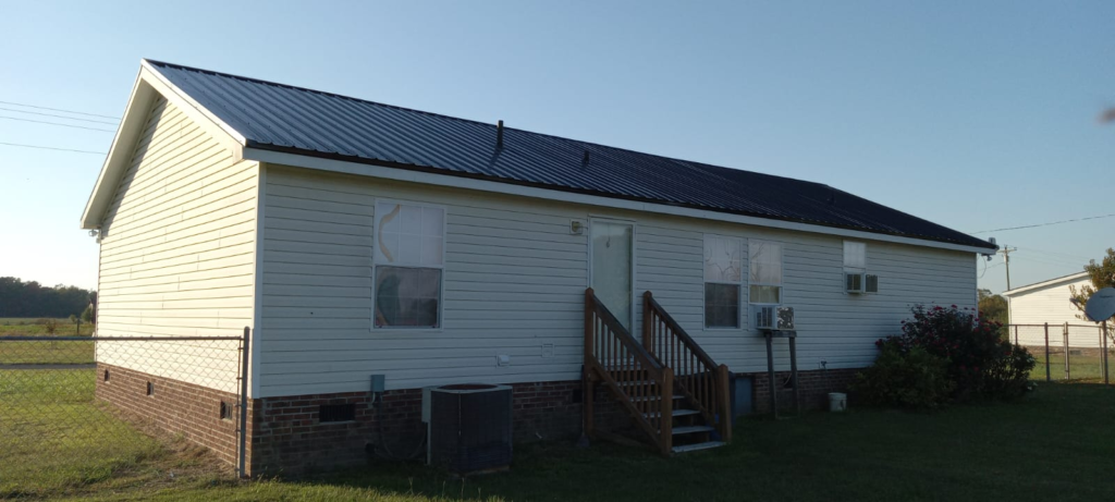 A white house with a black metal roof