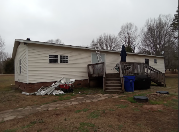  A large house with some debris laid out at the side of the house