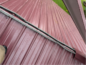 Raindrops on a red-colored metal roof
