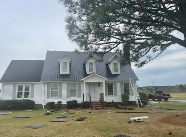 A large white house with a ladder next to the roof