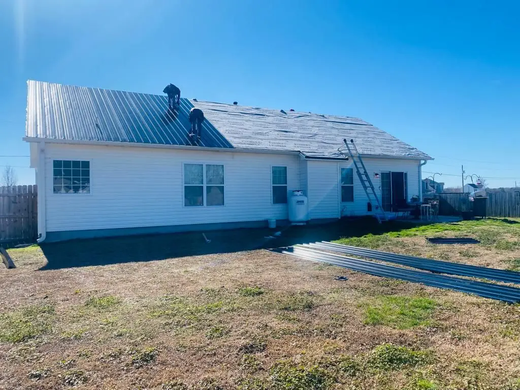 Roofers installing a metal roof