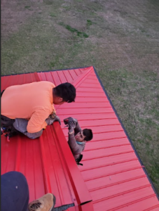 Two people are trying to fix the roof