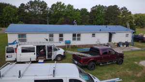 How to Make Your Sanford, NC, Home Environmentally Friendly 1 White Sanford, NC, home with energy-efficient blue metal roofing