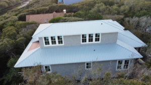 a beautiful house with a mint blue metal roof by Gator Metal Roofing