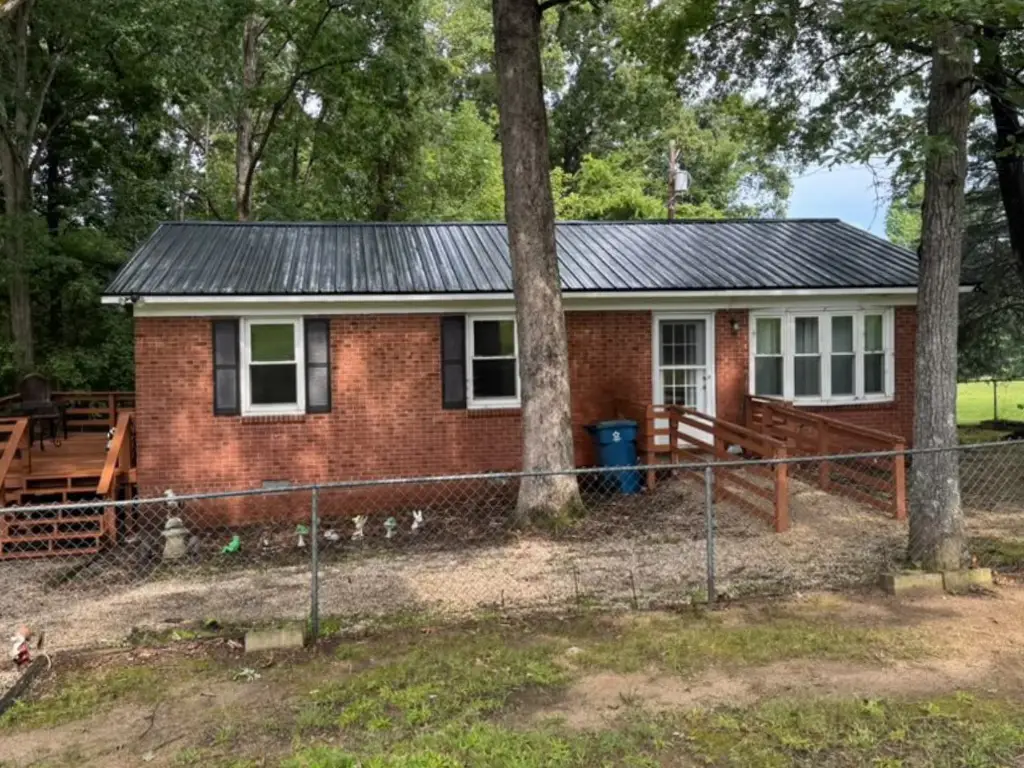 Completed black metal roofing installation on a brick home in High Point, NC.