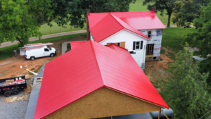 a beautiful home with a bright pink metal roof by Gator Metal Roofing