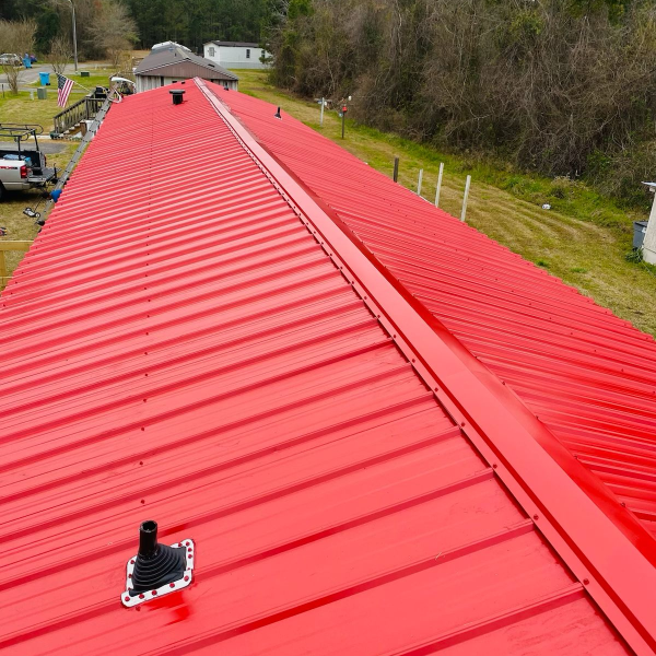 A close up shot of red metal roof panels on top of a residential property