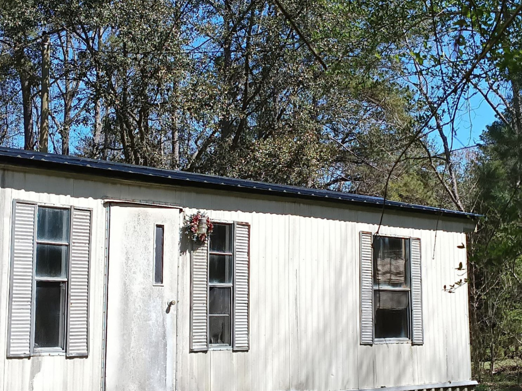 Closer photo of glossy black metal roofing on a white mobile home in South Carolina.