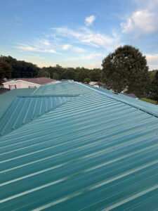Post installation view of a home's rooftop with new Forest Green metal roofing from Gator.