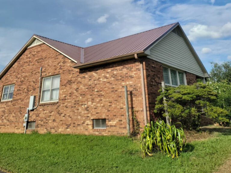 Completed metal roofing installation on a brick home in Winston-Salem, NC.