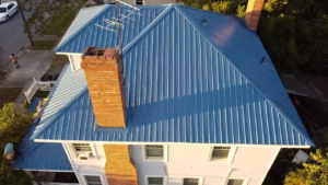 a house with a blue metal roof by Gator Metal Roofing