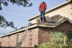 A person carrying out a roof repair and roof replacement.