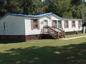 Metal Roofing vs. Traditional Roofing in Durham, NC: Why Metal Takes the Lead 1 A large house with several windows and a staircase opening into the yard.
